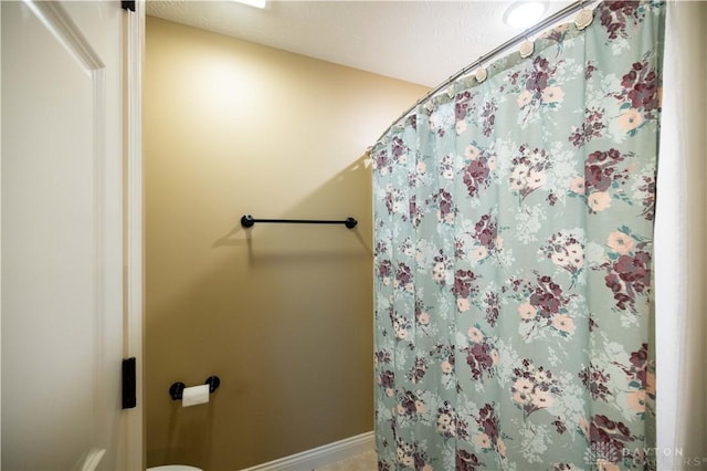 bathroom featuring toilet and a shower with shower curtain