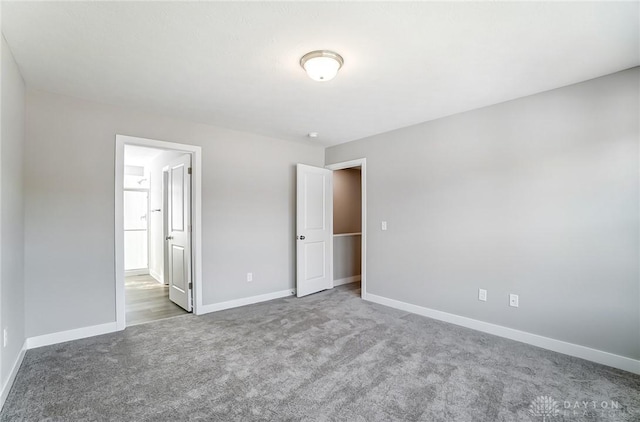 unfurnished bedroom with connected bathroom and carpet flooring