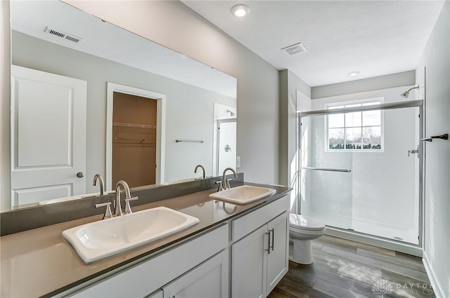 bathroom featuring vanity, toilet, hardwood / wood-style floors, and a shower with shower door