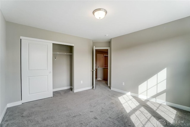 unfurnished bedroom featuring light colored carpet and a closet