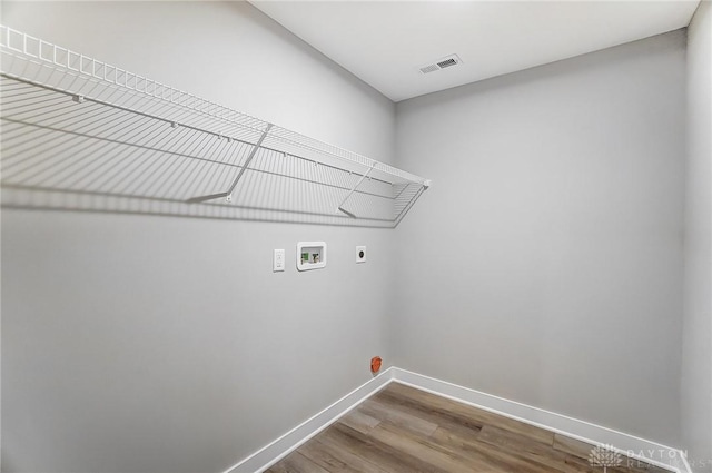 clothes washing area with hookup for a washing machine, hardwood / wood-style flooring, and hookup for an electric dryer