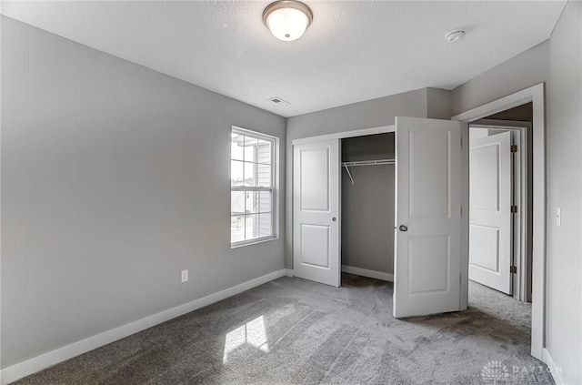 unfurnished bedroom featuring carpet flooring and a closet