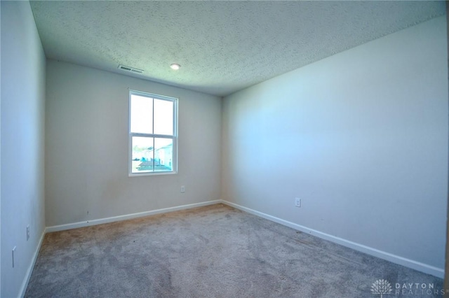 unfurnished room featuring carpet floors and a textured ceiling