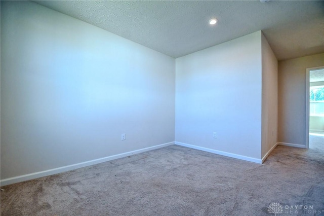 carpeted empty room with lofted ceiling and a textured ceiling