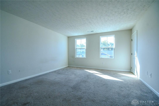 carpeted spare room featuring a textured ceiling