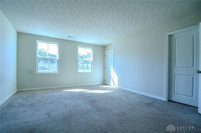 carpeted spare room featuring a textured ceiling