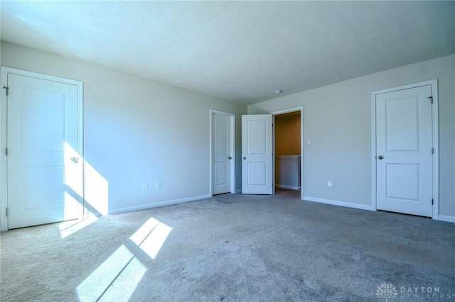 carpeted spare room featuring a textured ceiling