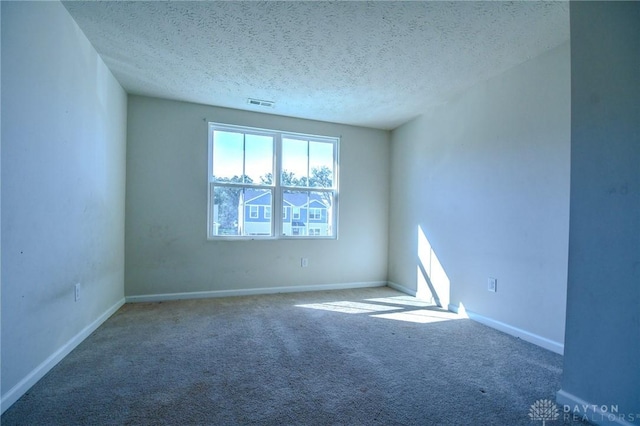 carpeted empty room with a textured ceiling