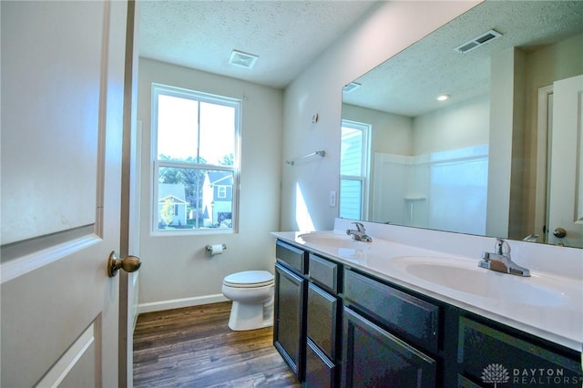 bathroom with hardwood / wood-style flooring, vanity, a textured ceiling, and toilet