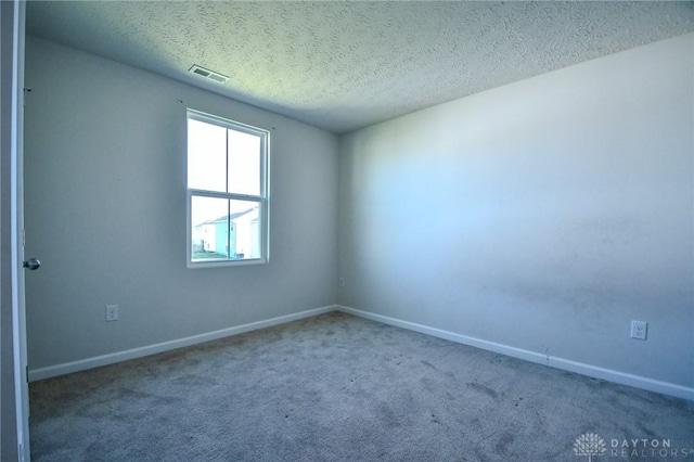 carpeted spare room with a textured ceiling