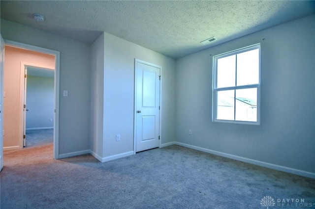 unfurnished bedroom with carpet flooring and a textured ceiling