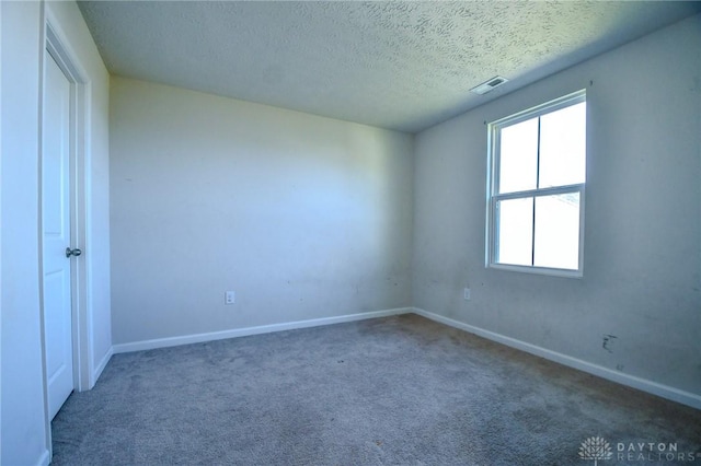 carpeted spare room featuring a textured ceiling