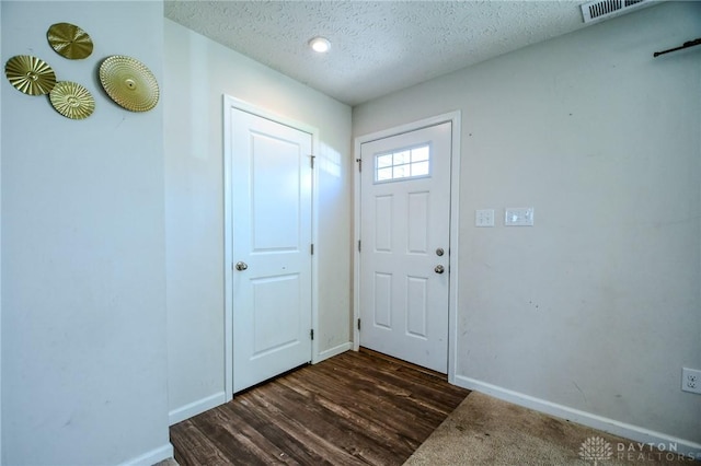 entryway with dark wood-type flooring and a textured ceiling