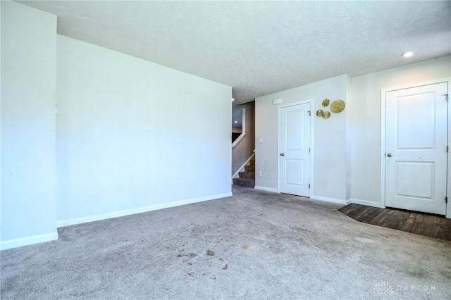 spare room with carpet flooring and a textured ceiling