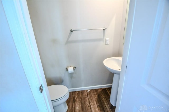 bathroom with hardwood / wood-style floors, sink, and toilet