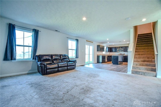 living room featuring carpet floors and a textured ceiling