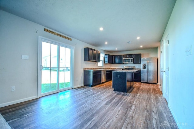 kitchen with hardwood / wood-style flooring, stainless steel appliances, and a kitchen island