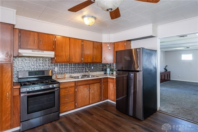 kitchen featuring appliances with stainless steel finishes, dark hardwood / wood-style flooring, sink, and backsplash