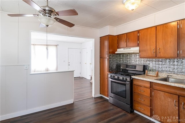 kitchen with stainless steel range with gas cooktop, dark hardwood / wood-style flooring, sink, and backsplash