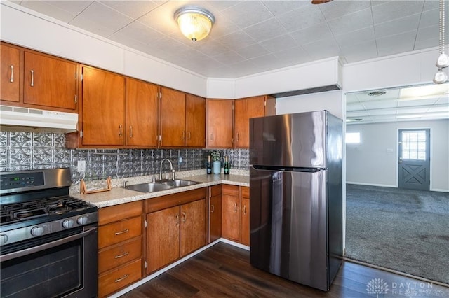 kitchen with appliances with stainless steel finishes, sink, dark hardwood / wood-style flooring, and decorative backsplash