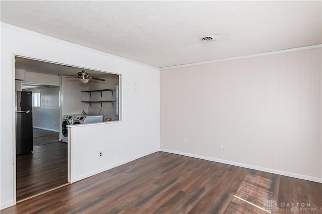 unfurnished room with crown molding, dark hardwood / wood-style floors, washer and dryer, and ceiling fan