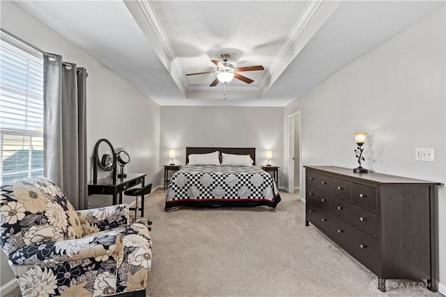 carpeted bedroom with a tray ceiling, ornamental molding, and ceiling fan