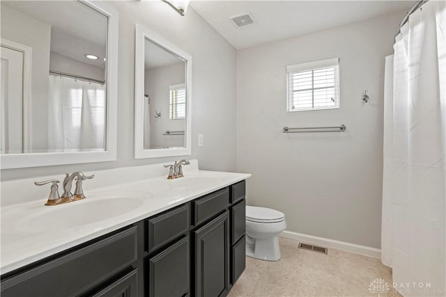 bathroom with vanity, a wealth of natural light, and toilet