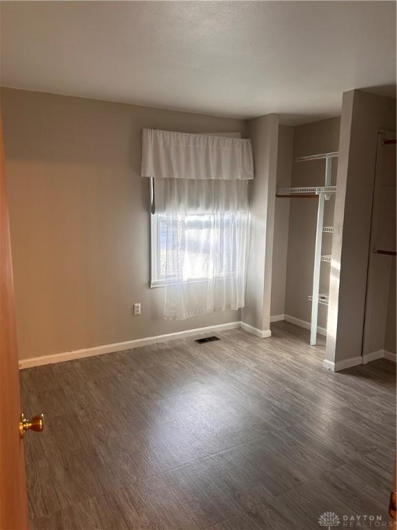 unfurnished bedroom featuring dark wood-type flooring and a closet