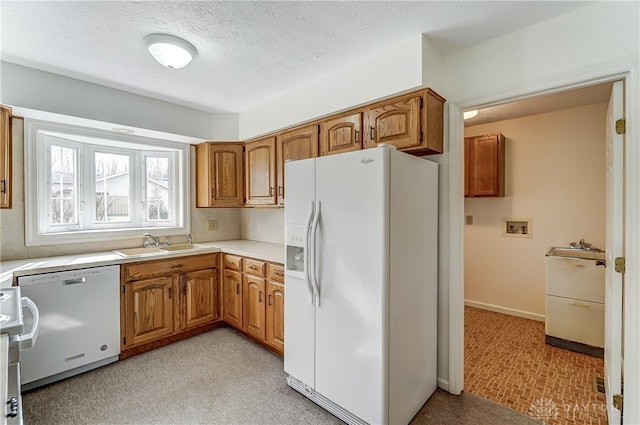 kitchen with white appliances, sink, and a textured ceiling