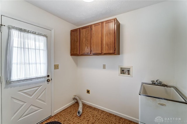 clothes washing area with washer hookup, cabinets, a textured ceiling, and hookup for an electric dryer