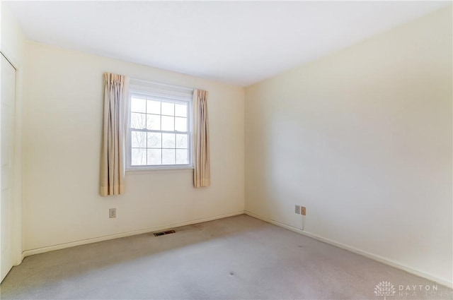 unfurnished room featuring light colored carpet