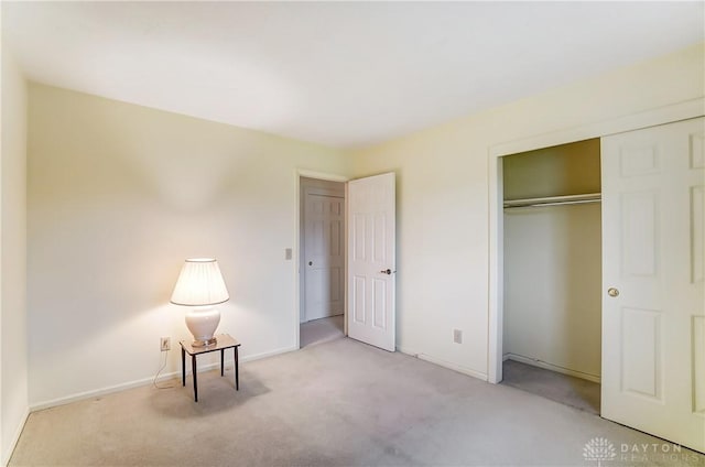 unfurnished bedroom featuring light carpet and a closet