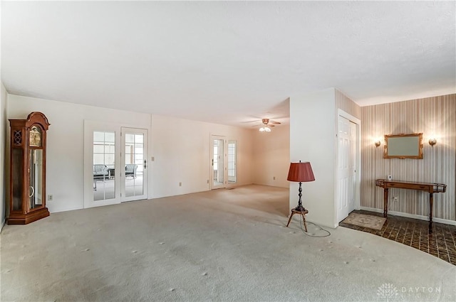 unfurnished living room featuring carpet floors, french doors, and ceiling fan