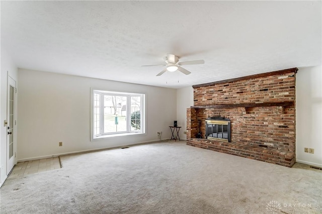 unfurnished living room featuring a fireplace, ceiling fan, a textured ceiling, and light colored carpet