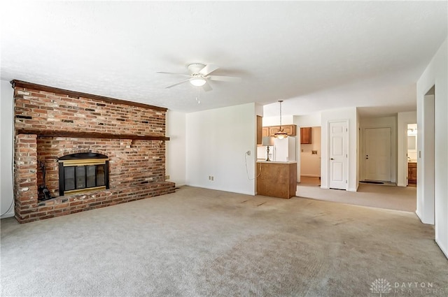 unfurnished living room with a fireplace, light carpet, and ceiling fan