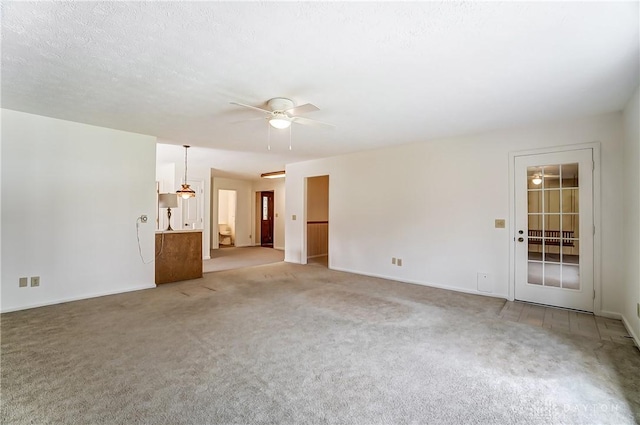 carpeted spare room with ceiling fan and a textured ceiling