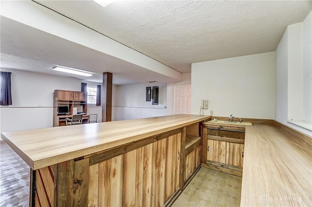 bar featuring a textured ceiling and butcher block countertops