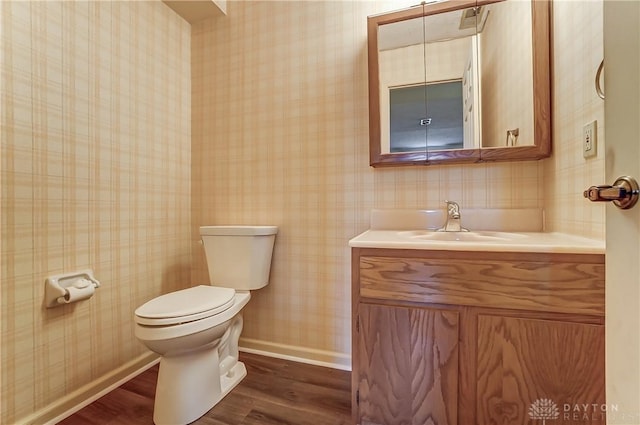 bathroom featuring toilet, vanity, and hardwood / wood-style floors