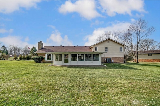 back of property featuring a lawn, central AC unit, and a sunroom