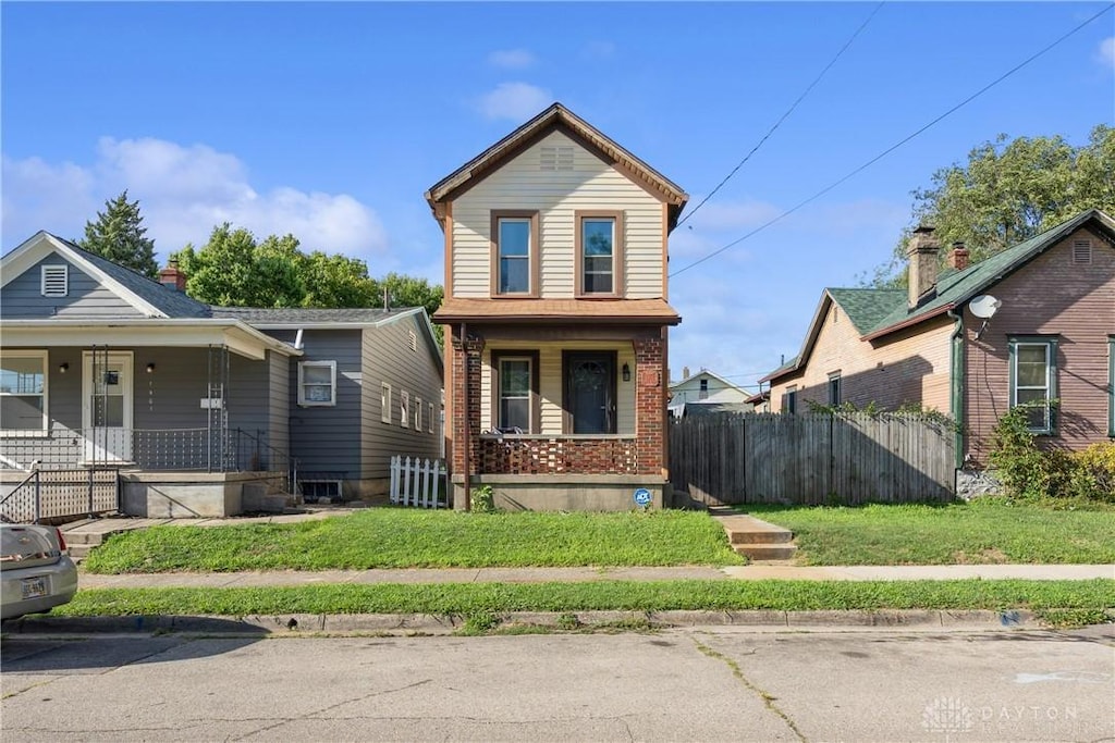 view of front property featuring covered porch and a front yard