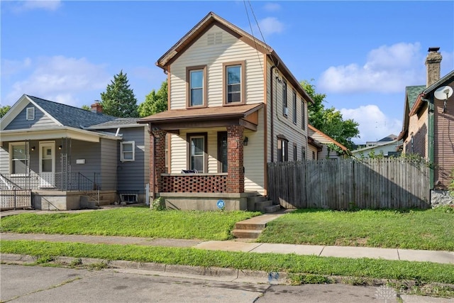 front of property with covered porch and a front yard