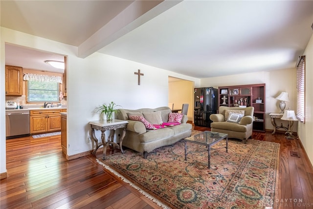 living room with beamed ceiling and dark hardwood / wood-style flooring