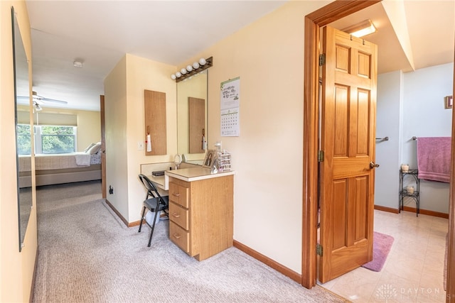 ensuite bathroom with baseboards, vanity, and carpet floors