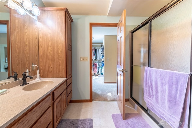 full bathroom with a stall shower, vanity, and baseboards