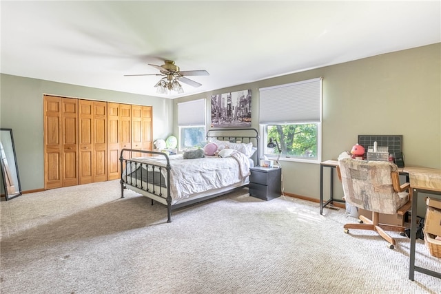 carpeted bedroom featuring a desk, baseboards, and ceiling fan