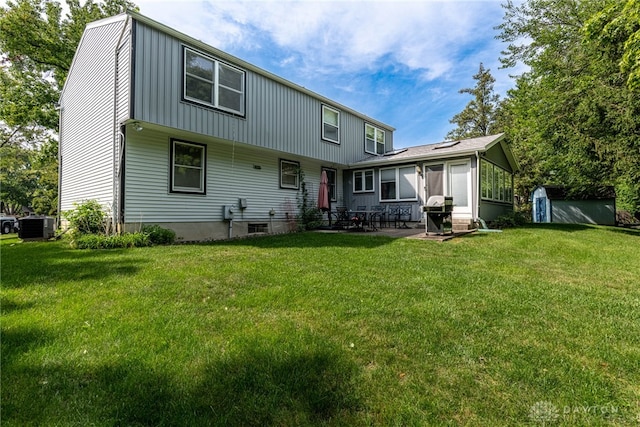 rear view of property featuring a yard, a patio area, cooling unit, and a shed