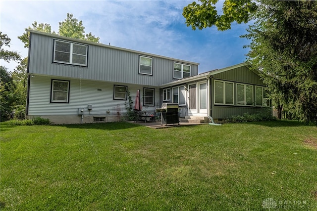 rear view of property with entry steps, a yard, and a patio