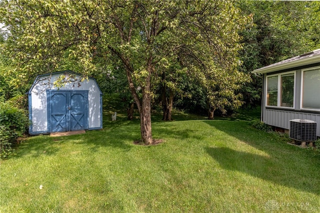 view of grassy yard with a storage unit, cooling unit, and an outdoor structure