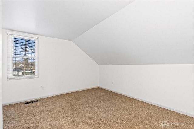 bonus room with lofted ceiling, carpet flooring, visible vents, and baseboards