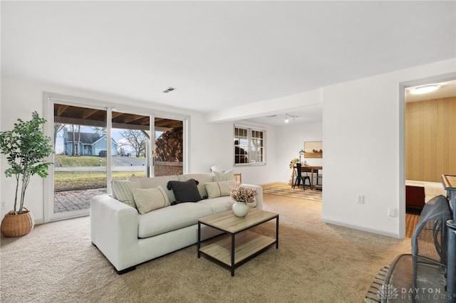 living room with carpet flooring, visible vents, and baseboards